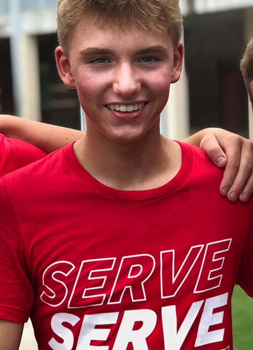Young man wearing a red shirt with the word serve on it